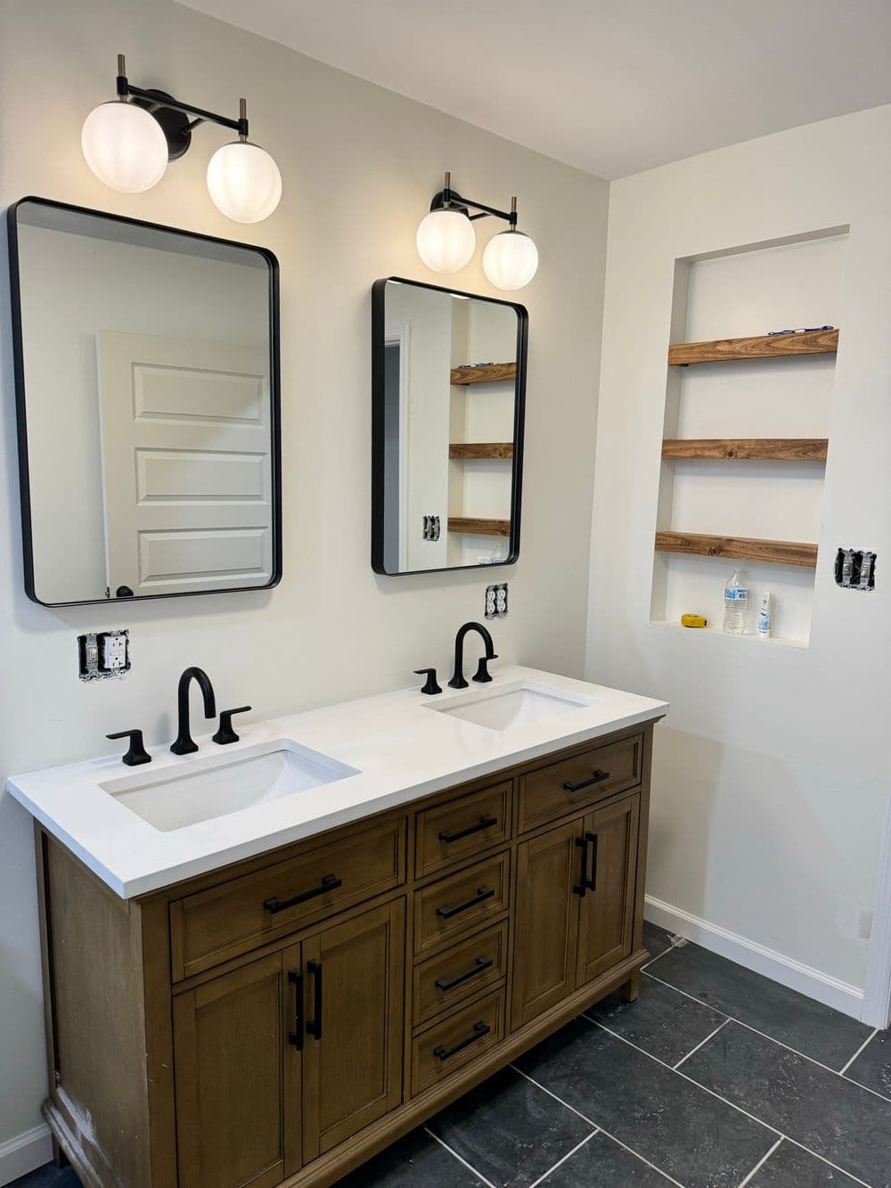 Modern bathroom with double sinks, sleek mirrors, and stylish lighting fixtures.