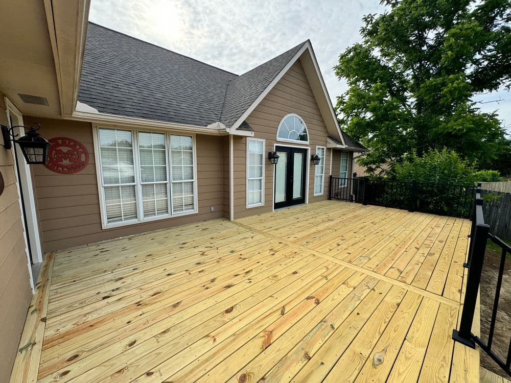 Newly renovated deck area with wooden flooring and attractive house facade. Bright, inviting space.
